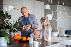 two children along with their grandfather in family kitchen